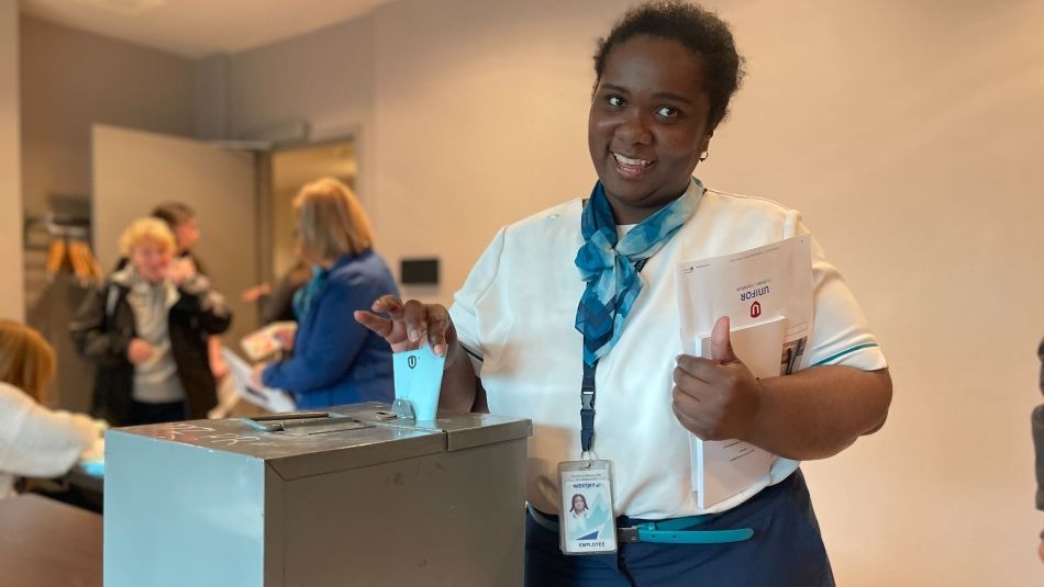 a black women places a ballot in a ballot box