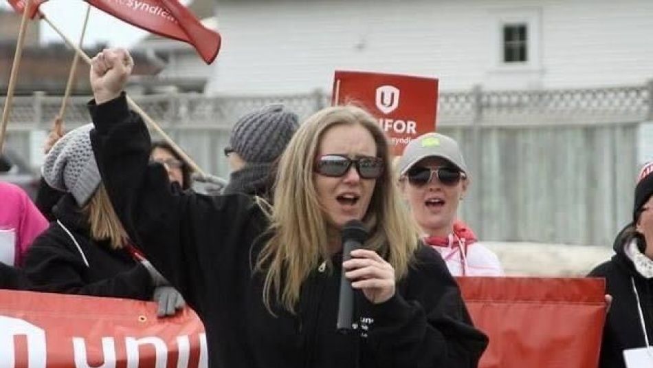 Kari Jefford, President of Unifor Local 229 speaks at a mic during a rally.