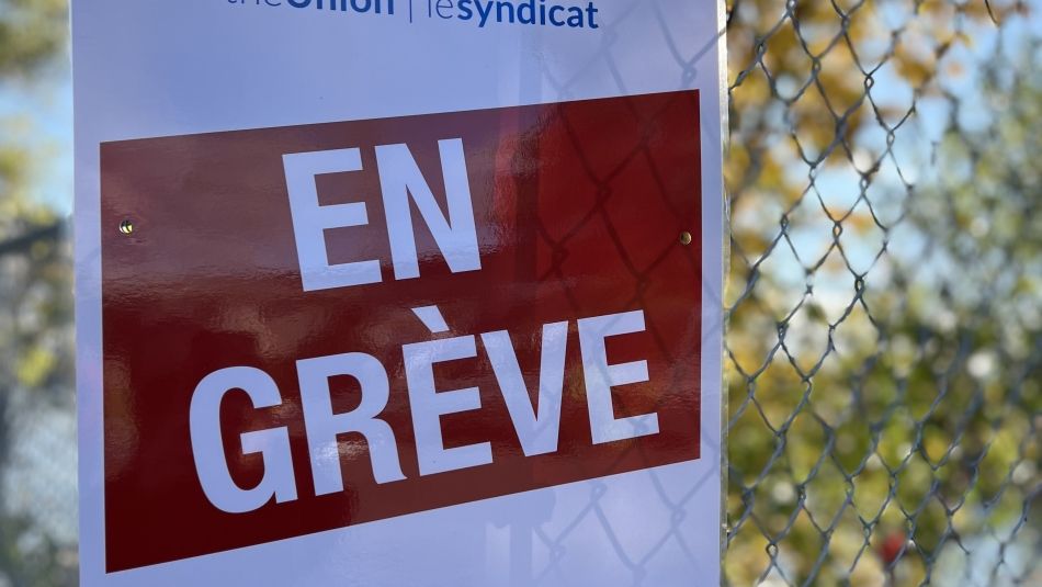 Unifor logo, on strike sign in French