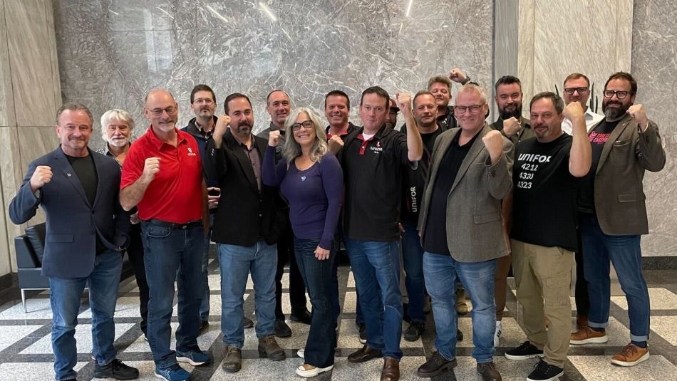 Unifor St. Lawrence Seaway Bargaining Committee a large group of people standing with their fits raised