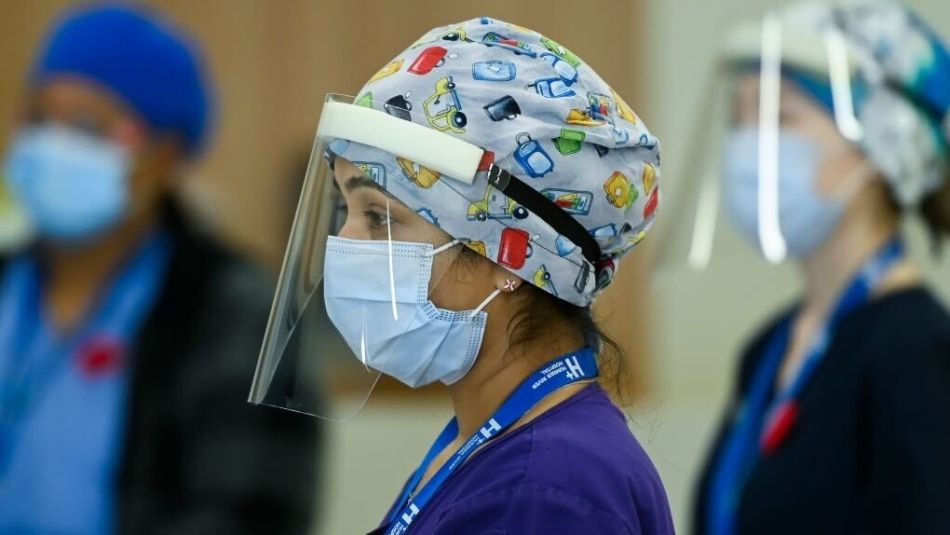 A nurse in a face sheild and mask