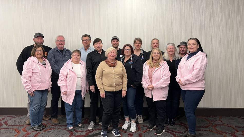 Bargaining committee poses for group photo in hotel meeting room.