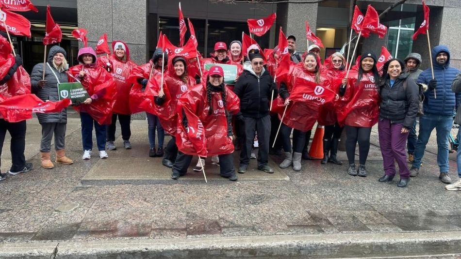 a group of people wearing red ponchos and holding flags