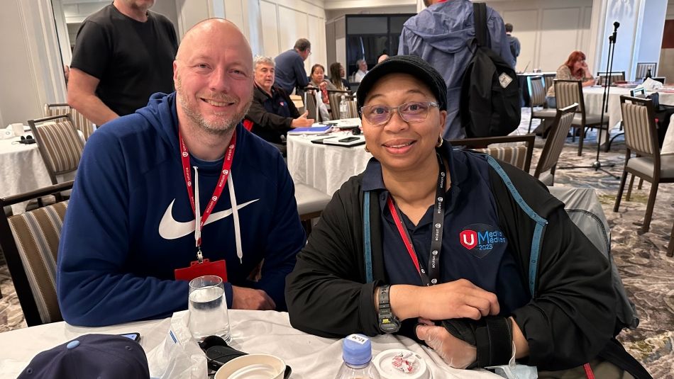 Two people posing at a table.