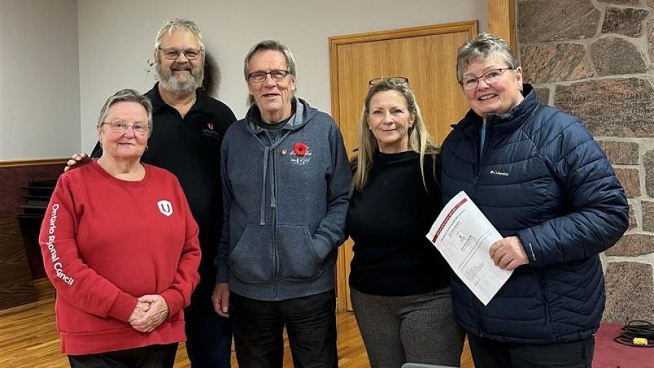 five people in sweaters smiling 
