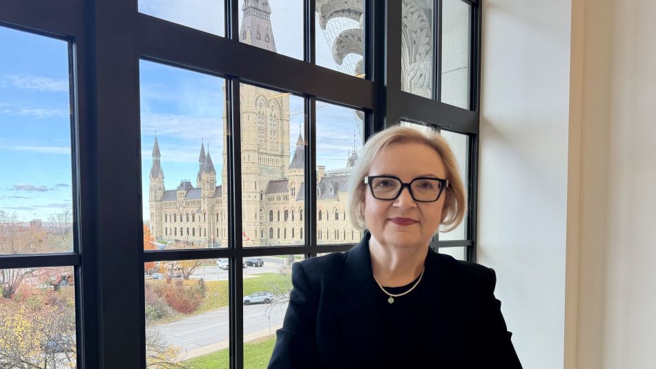 Lana Payne stands at a window in Parliament