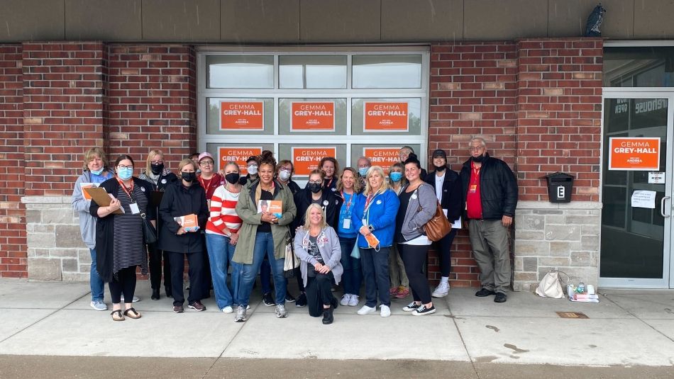 A group posing with vote Gemma Gray-Hall signs