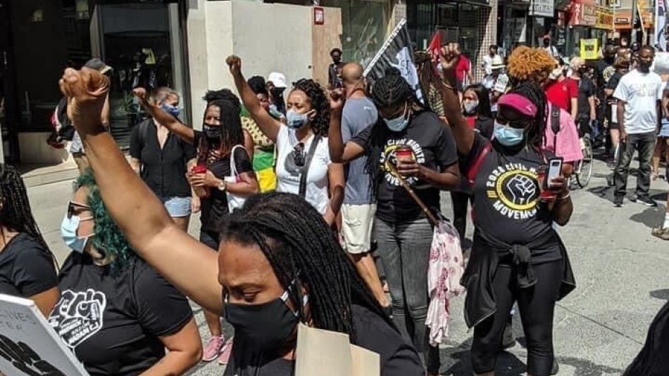 Des membres d'Unifor lèvent le poing lors d'une marche pour la justice raciale.