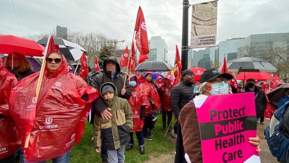 Unifor members join thousands of workers in the rain for May Day rally in Toronto.