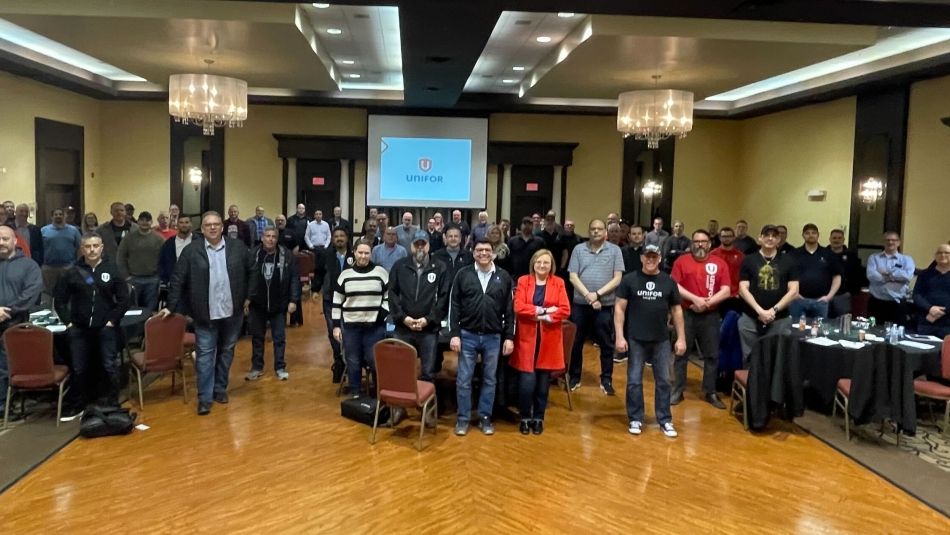 Unifor Auto Council members stand in meeting room 