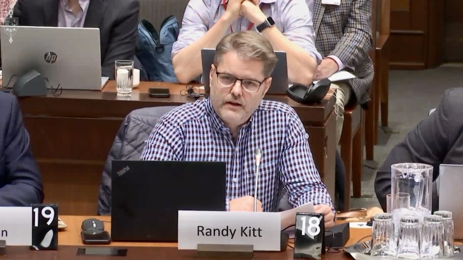 Man sitting at a table with a lap top in front of him