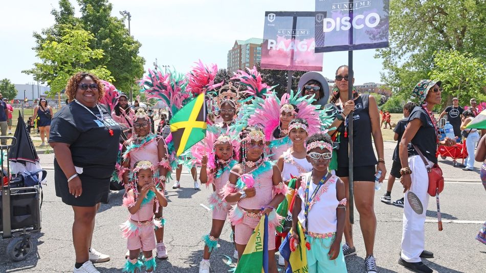 A group of people, some in colourful feathered costumes.