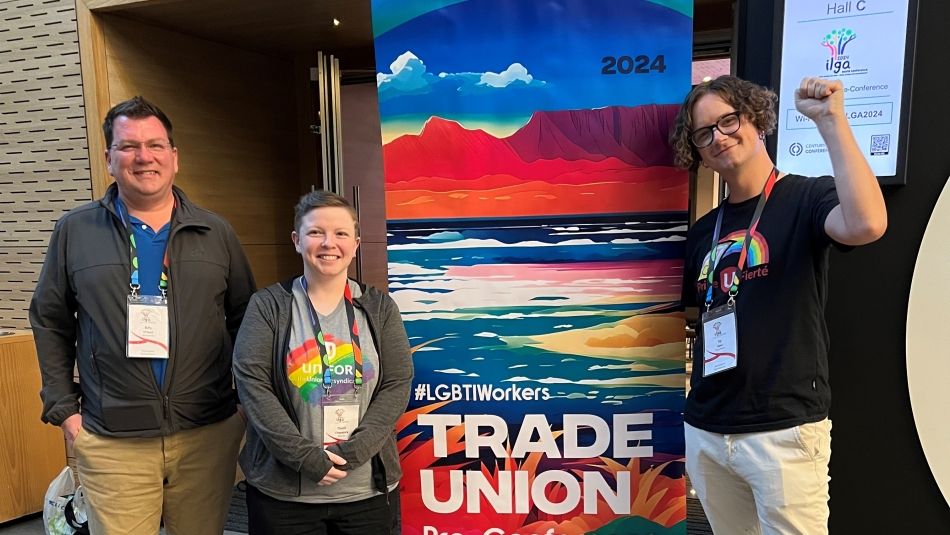 Three people standing beside a pop up banner