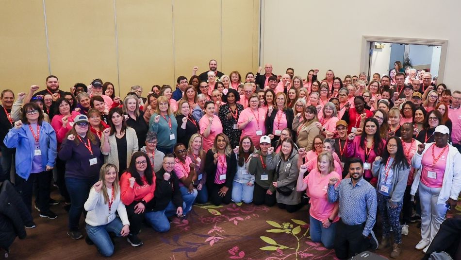 A very large group fists raised, some wearing pink shirts.