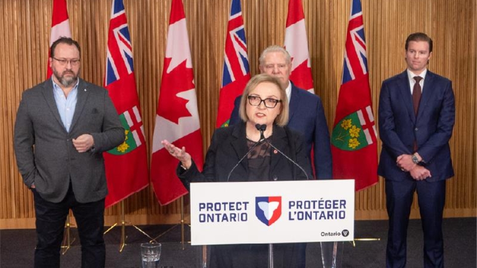 Unifor Lana Payne standing at a podium that reads Protect Ontario. 