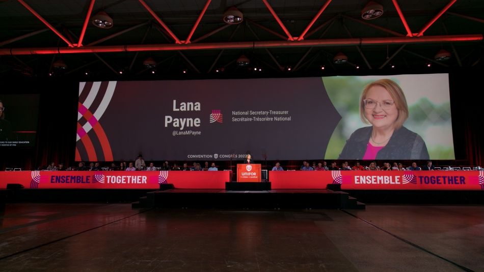 View of Lana Payne standing on stage at Convention