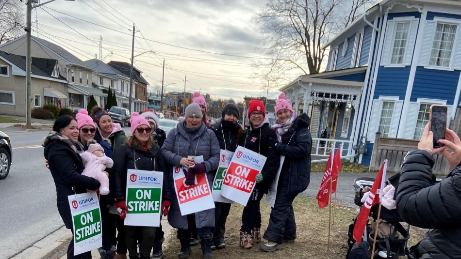 Women holding picket signs smiling 