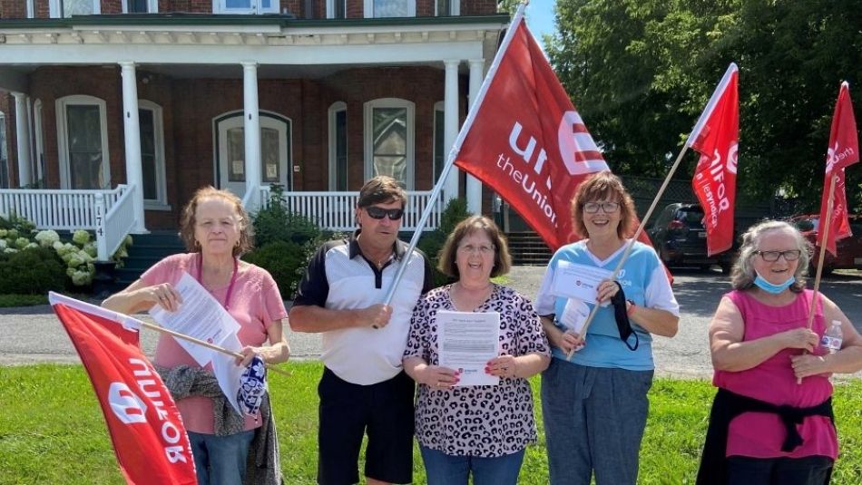 Shelter workers on the picket line holding flags