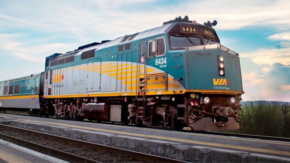 Locomotive et wagons de VIA Rail en mouvement au coucher de soleil