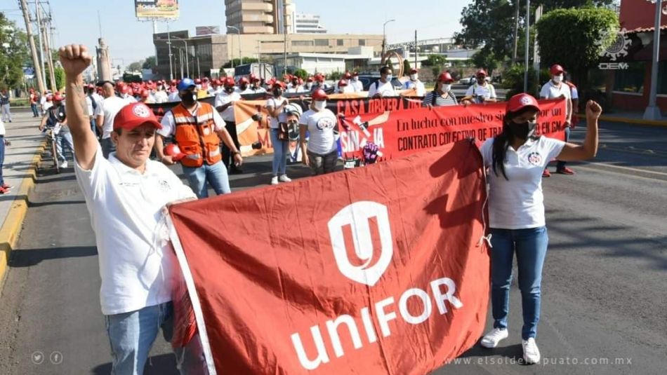 Des travailleurs de GM à Silao portent un drapeau d’Unifor lors de leur manifestation à l’occasion de la Journée internationale des travailleuses et des travailleurs