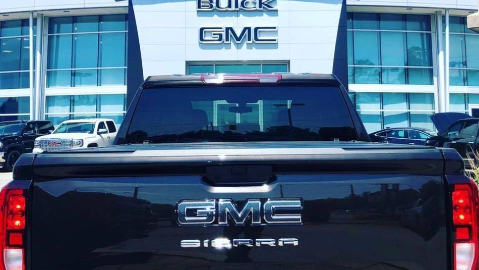 A large black truck outside a Buick GMC dealership