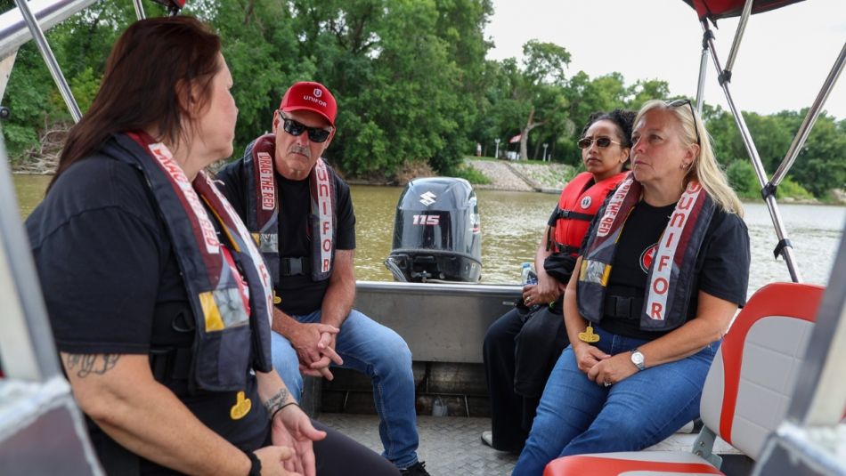 Poirier, Hashi, and Murray listening to Jill Wilson while sitting on a power boat).