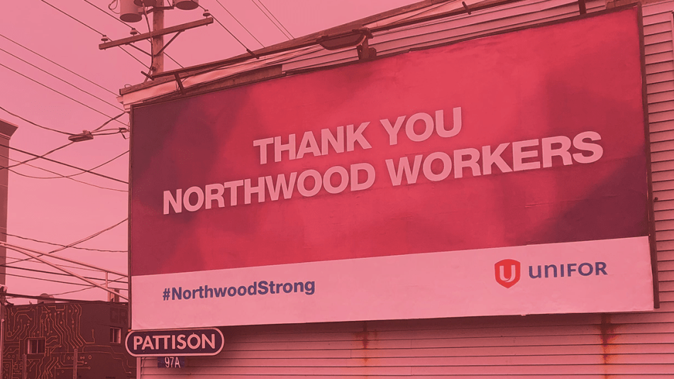 Un panneau d'affichage soutenant les membres d'Unifor travaillant au foyer de soins de longue durée de Northwood, vu dans une rue de Halifax. L'image est teintée de rouge.