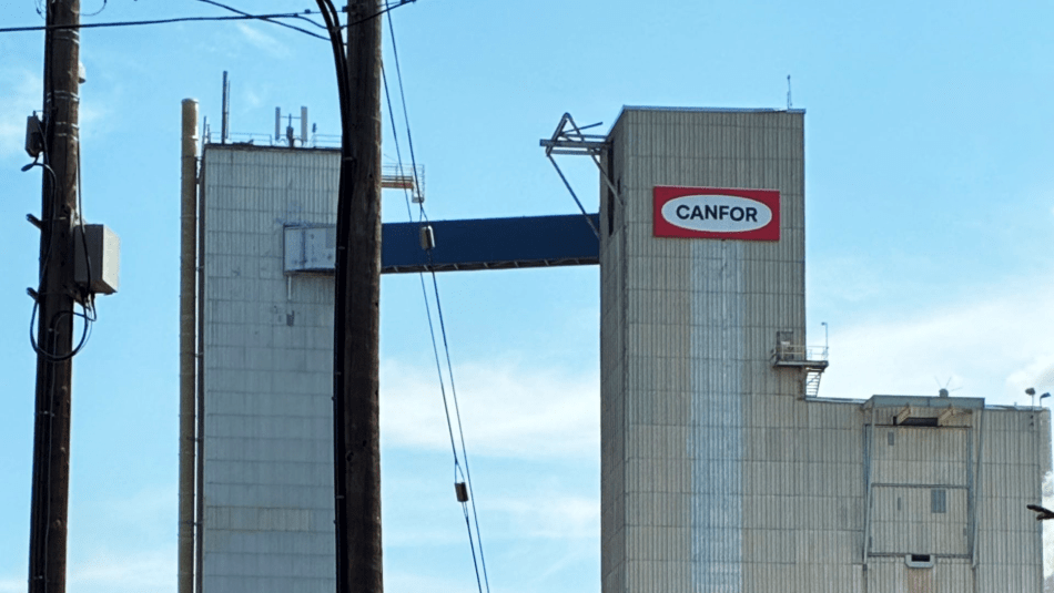 Grey towers at an industrial site with signage reading Canfor.