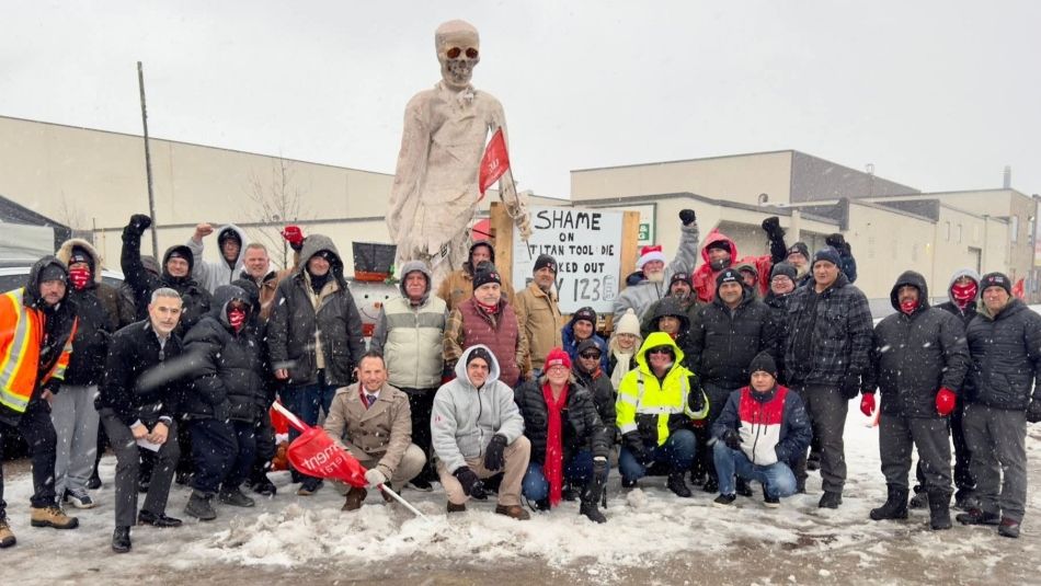 a large group of workers outside around a extra large skeleton