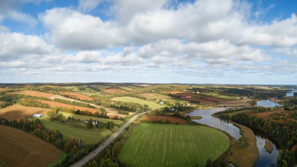 An aerial view of farm fields bordering a winding river in Prince Edward Island.