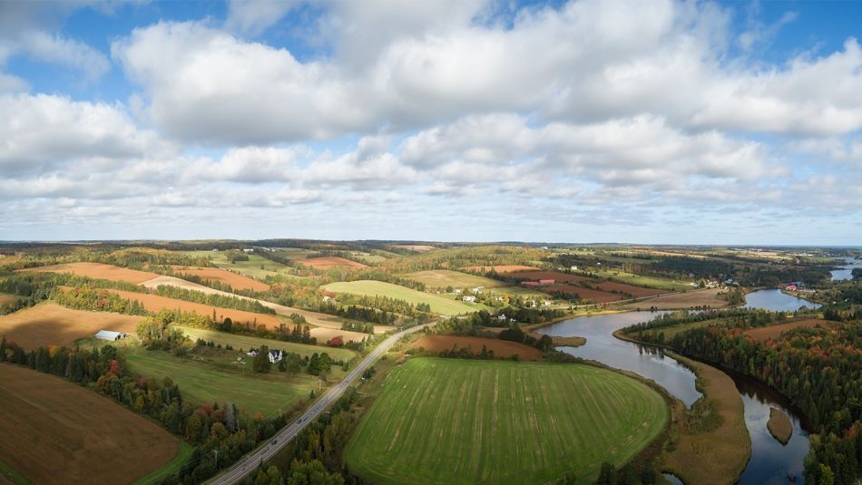 Vue aérienne de champs agricoles bordant une rivière sinueuse dans l'Île-du-Prince-Édouard.