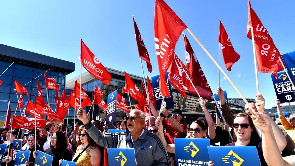 A group of people holding red Unifor flags