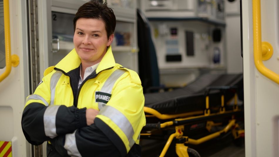 Paramedic in uniform outside of an ambulance