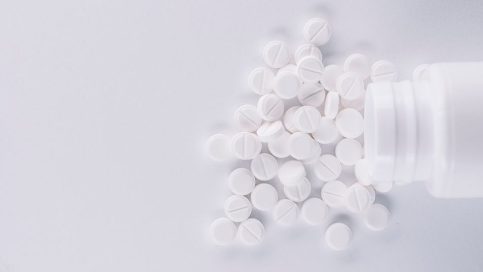 A spilled bottle of round white pills