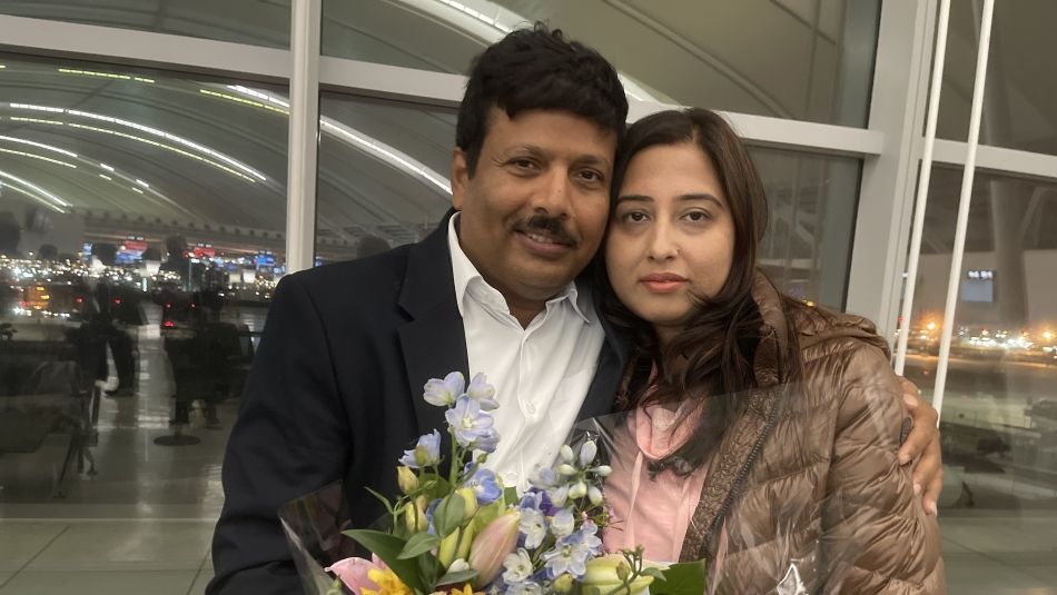 BK Dubey and his wife hold flowers.