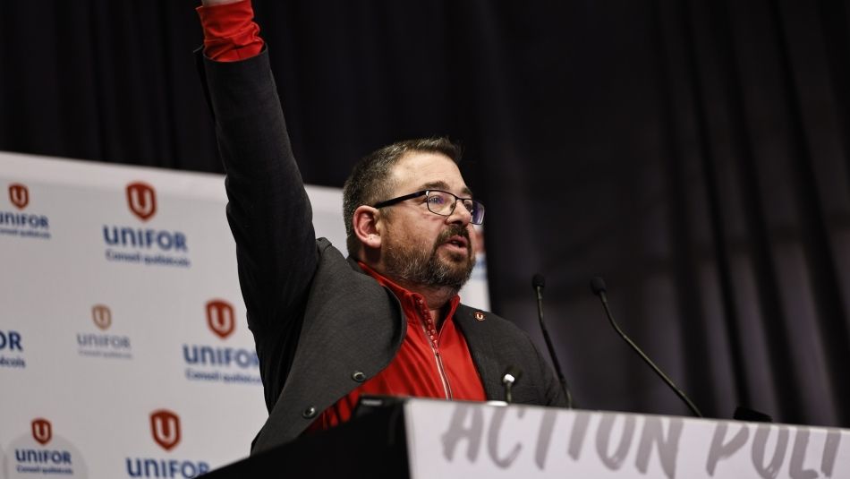 Le directeur du Québec, Daniel Cloutier, sur un podium, le poing levé en l'air.