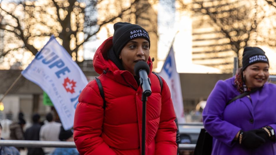 Samia Hashi wears a "Save Our Hospitals" toque while speaking at a health care rally.