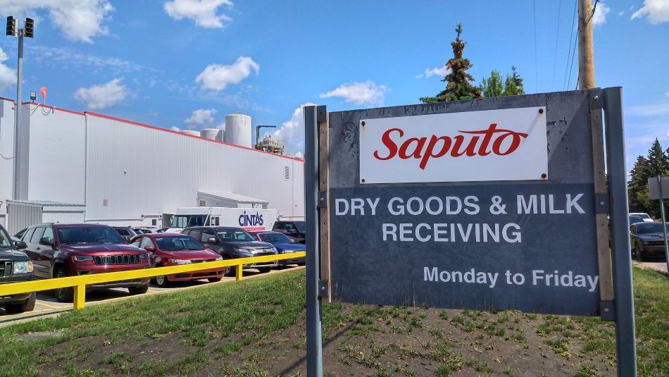 A Saputo sign with a warehouse in the background.