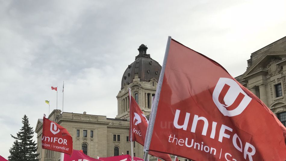 Saskatchewan legislature building with Unifor flags in the foreground