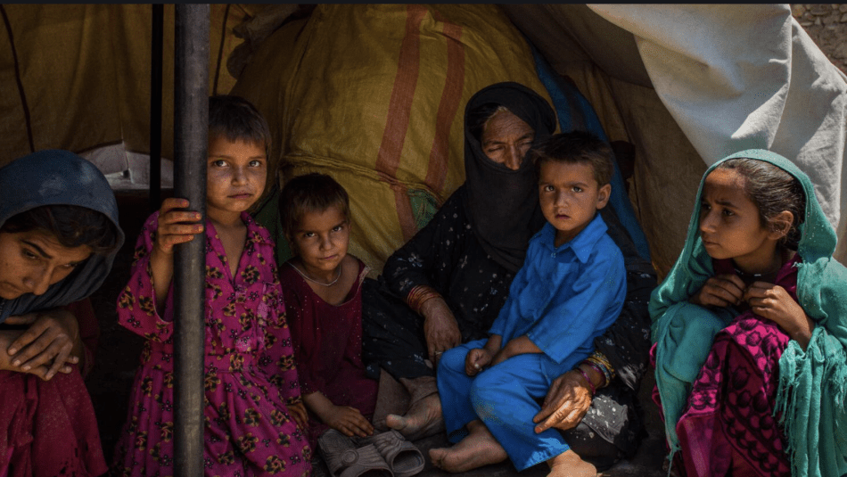Enfants afghans assis dans une tente