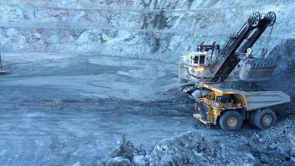 Chargement d'un camion-benne de taille industrielle dans une mine à ciel ouvert.