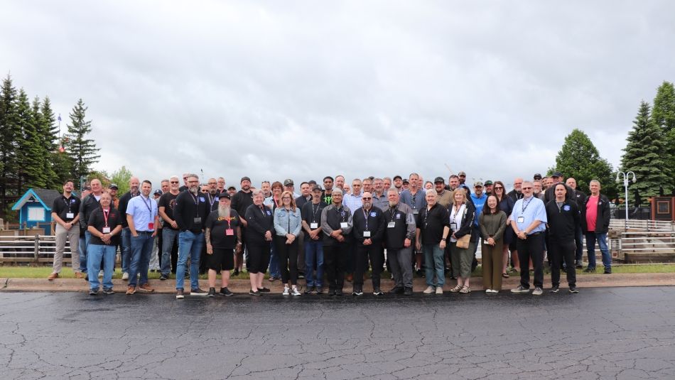 A large group photo outside on a cloudy day.