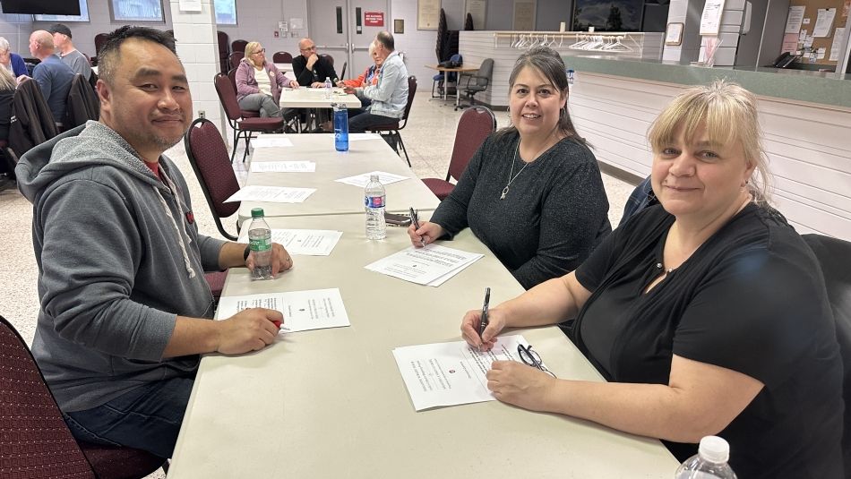 St. Catharines BWP meeting people sitting at a table with pens and papers