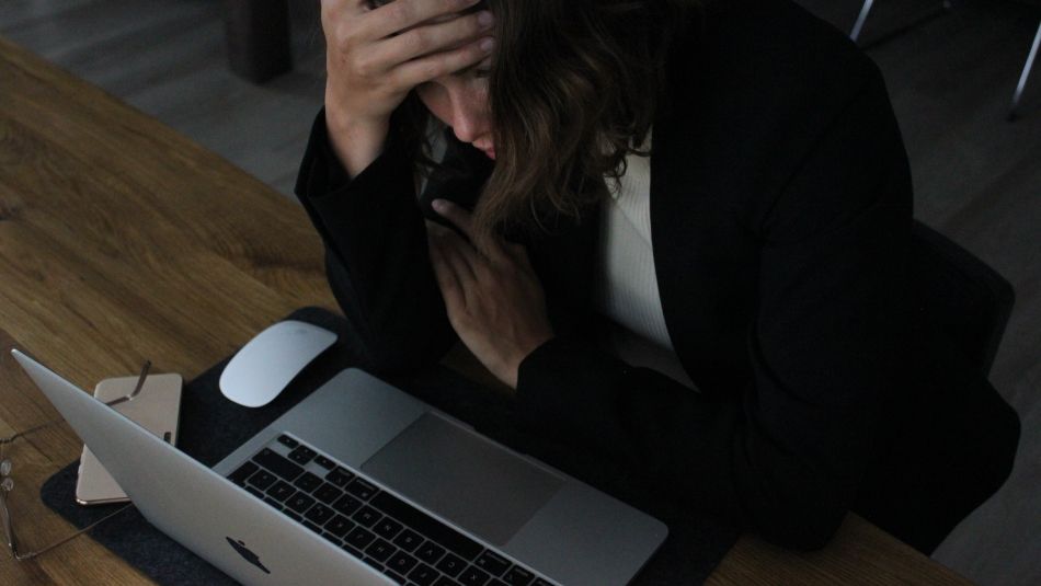 Woman under stress at her laptop 