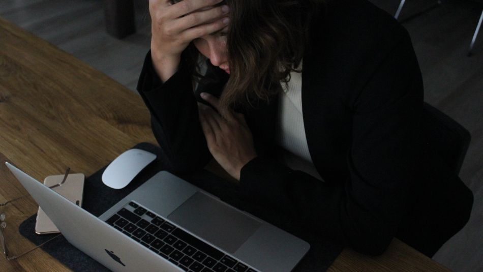 A stressed journalist sits at her laptop