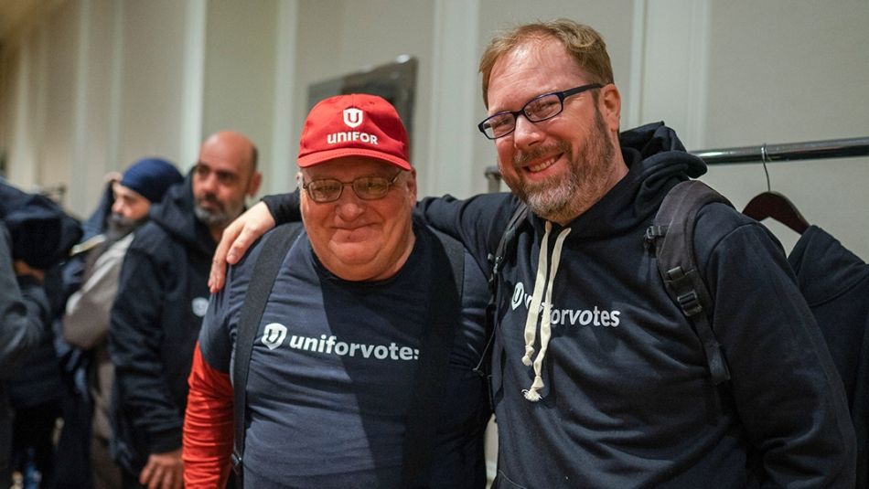 Deux hommes portant des t-shirts de vote Unifor