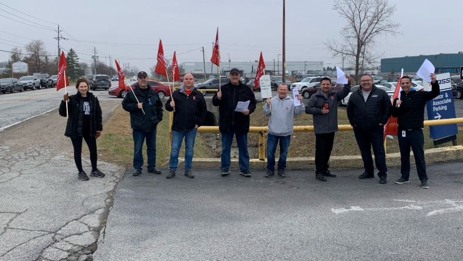 TQRSS workers holding up Unifor flags and copies of their new contract highlights.