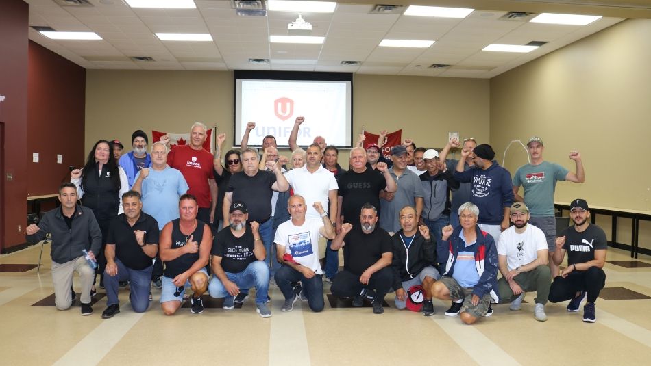 A large group in a conference room two rows first is kneeling 