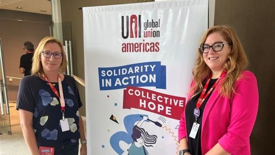two women standing beside a pop up banner