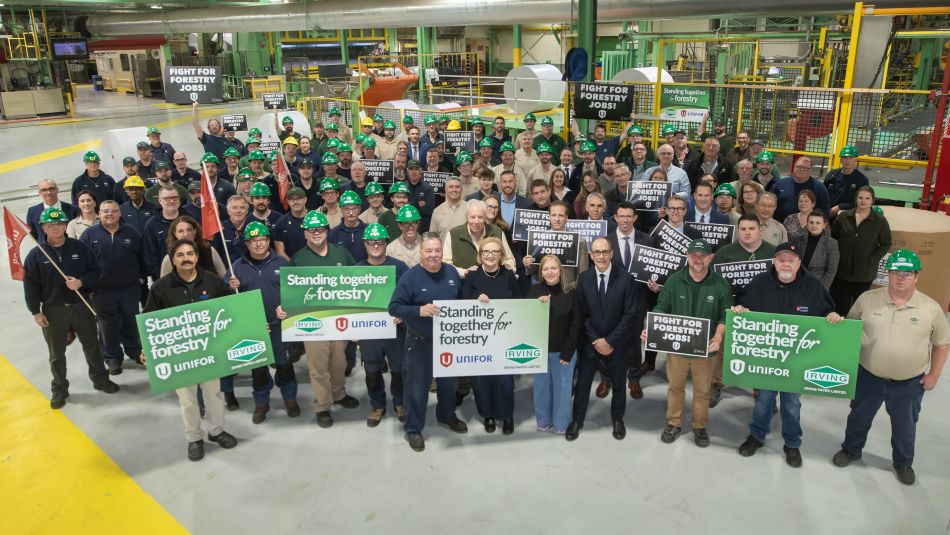Large group of workers and managers at Irving holding signs reading 'Standing together for forestry'